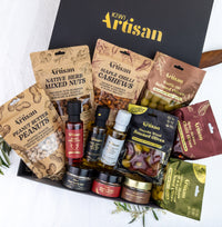Assorted gourmet food items in a 'Kiwi Artisan' box on a white background