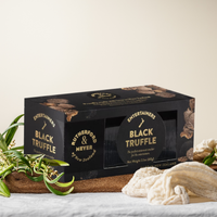 Black truffle cracker packaging with decorative elements on a neutral background