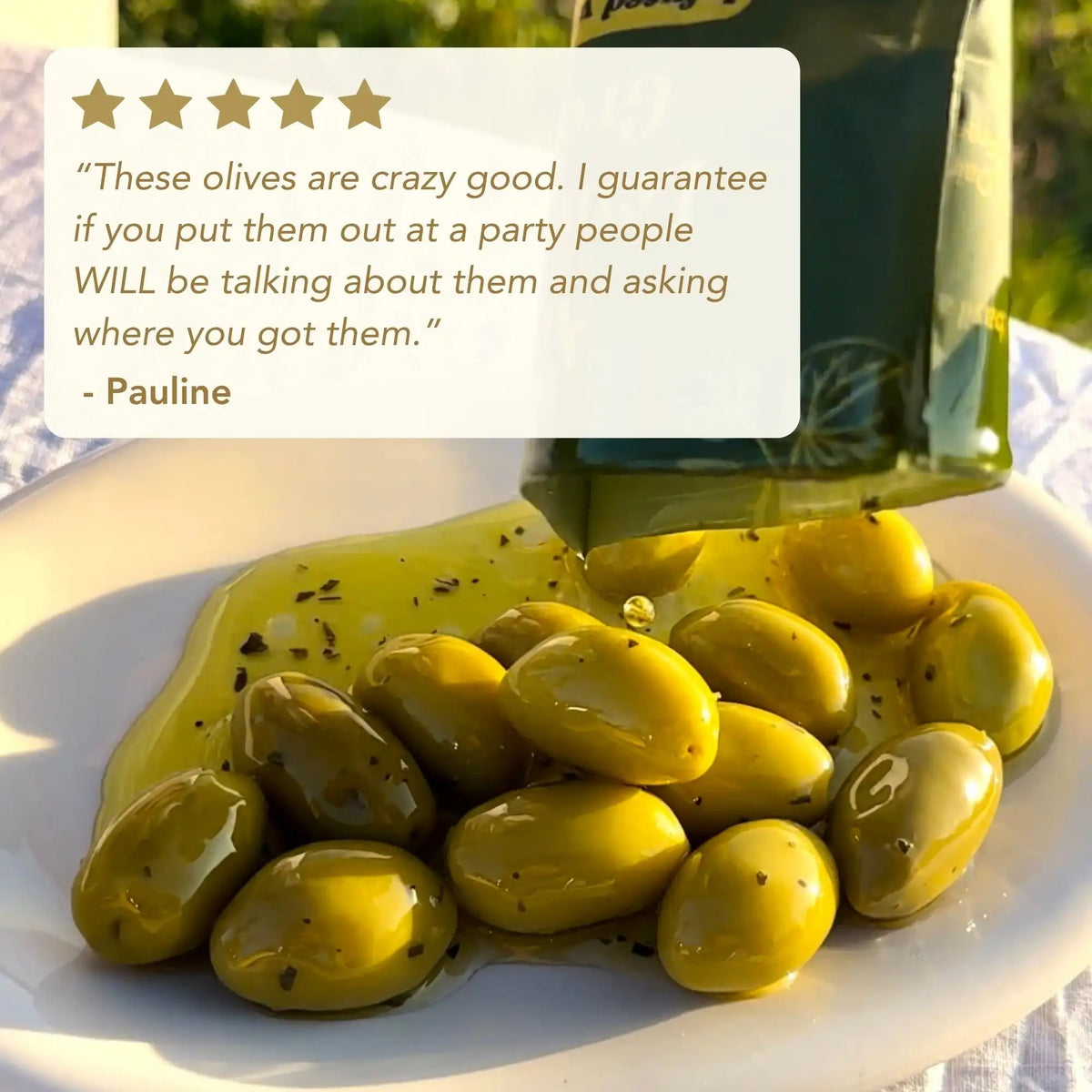 Green olives on a plate with a bottle of olive oil, featuring a customer review.