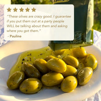 Green olives on a plate with a bottle of olive oil, featuring a customer review.