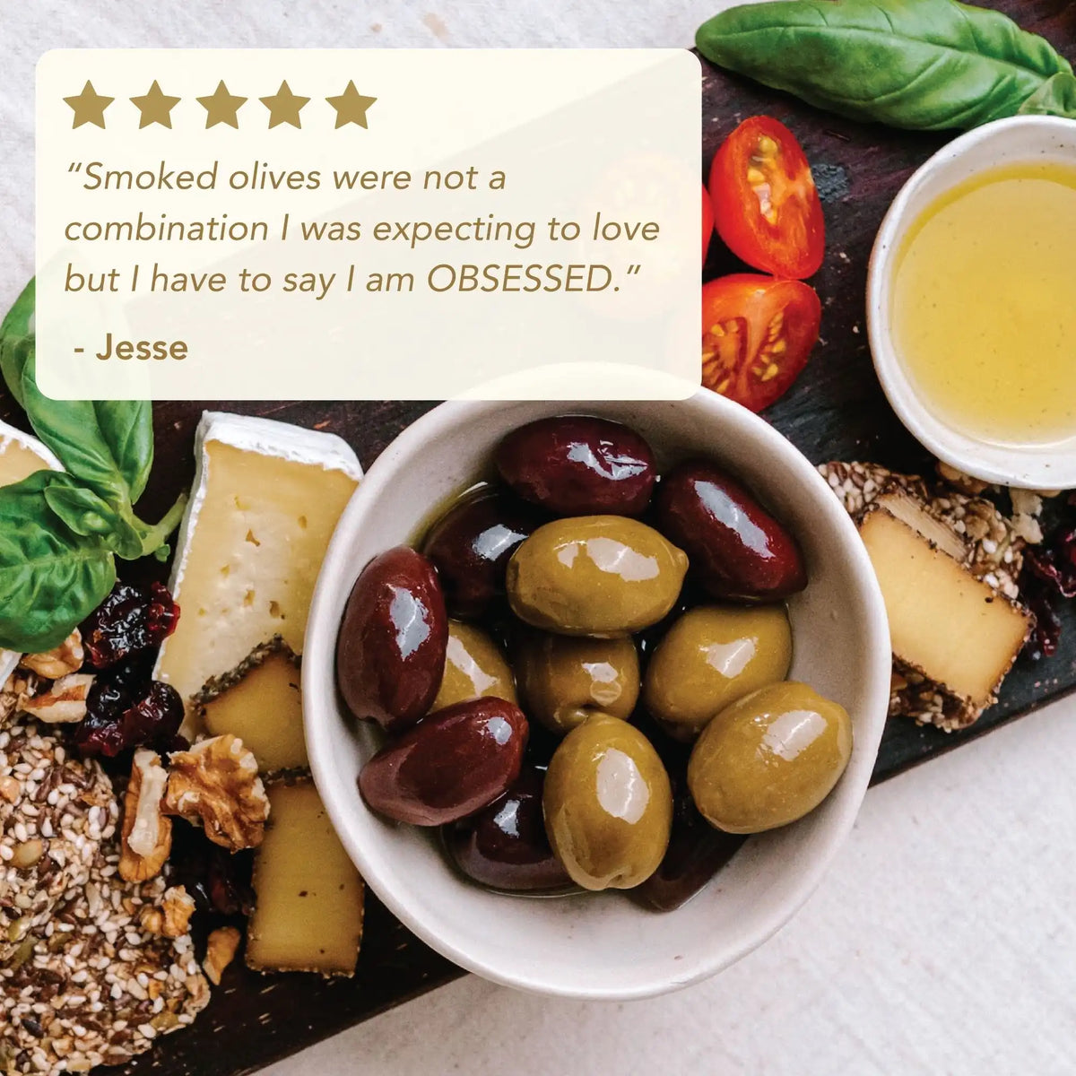  bowl of olives on a platter with cheese, tomatoes, and basil
