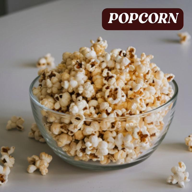 Clear glass bowl filled with truffle popcorn on a light surface, with 'POPCORN' text above.